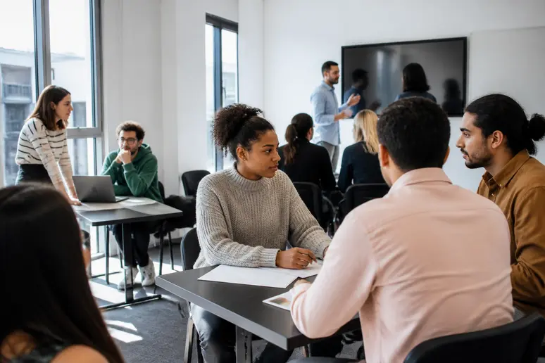 Des apprenants concentrés échangent avec des formateurs dans un centre de formation moderne à Rennes, Bretagne, France.