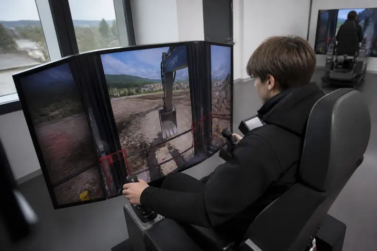 Apprenti s'exerçant sur un simulateur d'engins de chantier, illustrant l'équipement pédagogique de pointe du CFA TP.