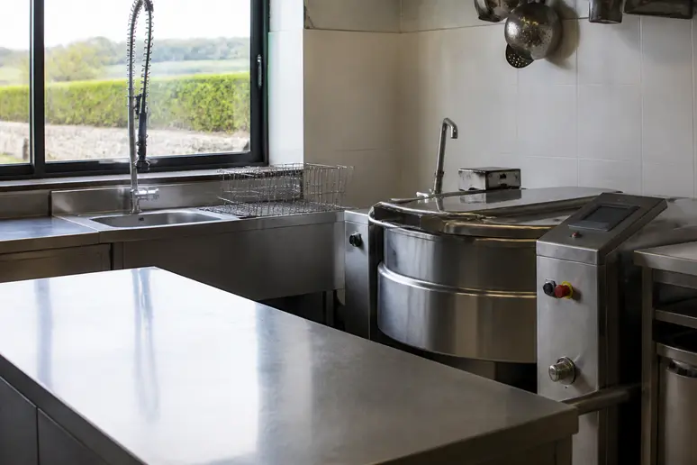 Plan de travail en inox propre dans un atelier de transformation alimentaire artisanal en Bretagne.