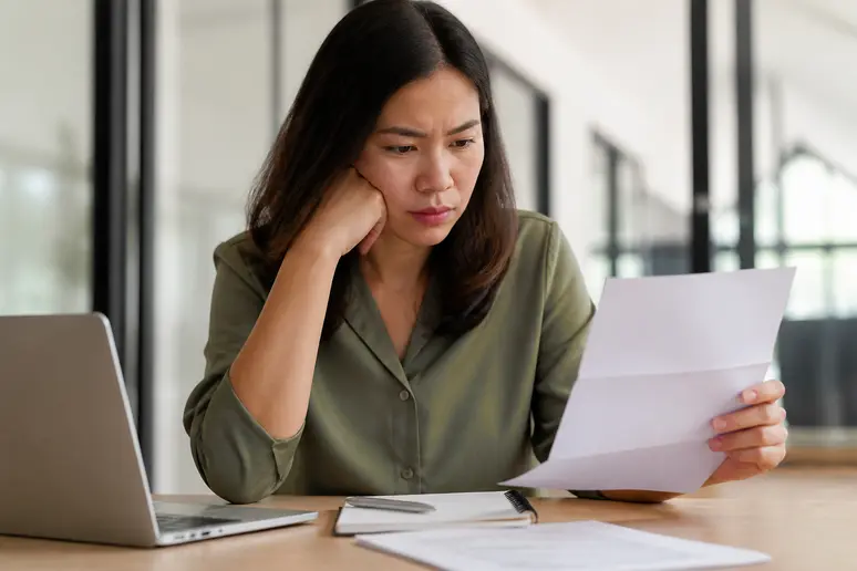 Employé vérifiant le bulletin de paie et les heures de travail dans un bureau