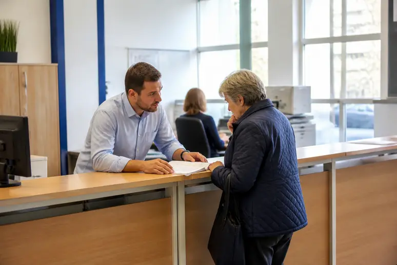 Agent municipal renseignant un administré à l'accueil de la mairie de Vitré