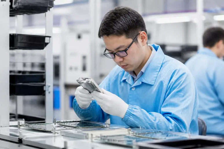 Ingénieur en électronique analysant des prototypes dans le centre d'excellence de Thales Étrelles