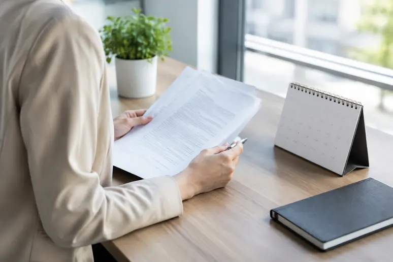 Consultation d'un calendrier et de documents professionnels pour planifier le congé