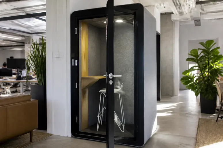 Cabine acoustique individuelle insonorisée installée dans un espace de travail partagé pour téléphoner au calme.